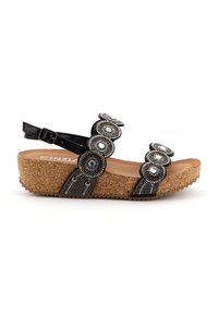 Sandalo nero con accenti circolari di perline e suola a zeppa in sughero. Presenta cinturino regolabile e suola textured per una maggiore aderenza.