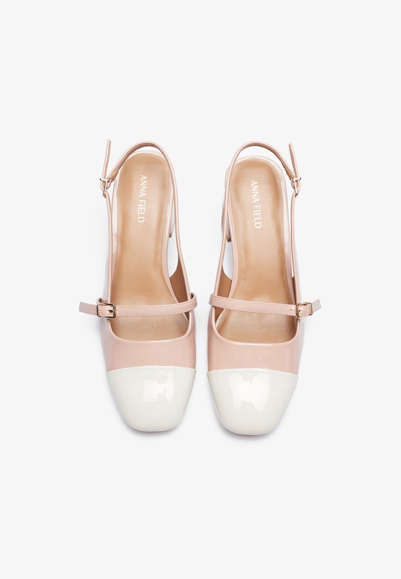 Scarpe slingback in patent rosa chiaro, con una punta tonda bianca e un sottile cinturino alla caviglia con fibbia regolabile.