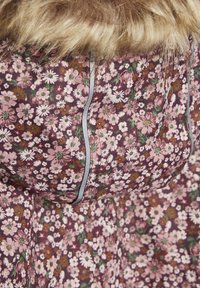 Stoff mit floralem Muster in Rosa- und Lila-Tönen mit grünen Akzenten. Verfügt über eine Kunstpelz-Kapuze und graue Paspel entlang der Nähte.