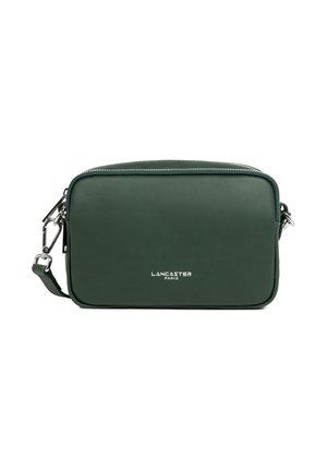 Borsa a tracolla in pelle verde con bordi arrotondati, hardware argentato e chiusura a zip. Presenta un logo impresso sulla parte anteriore. Texture liscia.