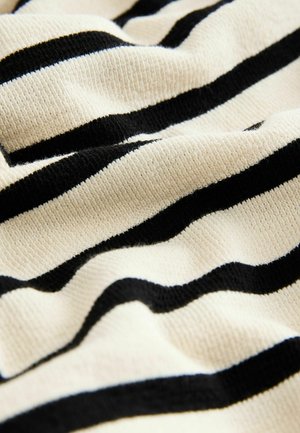 Strickstoff mit abwechselnd breiten Streifen in Creme und Schwarz, der eine strukturierte Oberfläche und ein weiches Aussehen präsentiert.