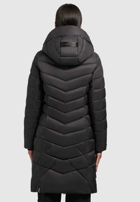 Schwarze Daunenjacke mit einem Chevron-Steppmuster, einer großen Kapuze und einem Markenetikett auf der Rückseite. Sie hat lange Ärmel und ein mittellanges Design.
