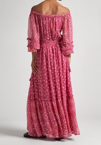 Off-the-shoulder pink maxi dress with ruffled sleeves, floral and diamond patterns, elastic waist, and tiered hem. Translucent fabric.