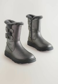 Metalen grijze winterlaarzen tot halverwege het kalf met zwarte zolen, nep-bont voering, een rits aan de zijkant en twee verstelbare gespen aan de buitenkant.