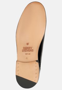 Schwarze Leder-Schuhsohle mit einem glatten, hellbraunen Fußbett. Mit "HENRY STEVENS BERLIN" eingraviert und Gummi-Akzenten für besseren Halt.