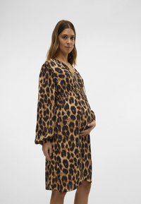 Vestido de estampado de leopardo con mangas largas, escote en forma de V y cintura fruncida. Confeccionado en una tela suave, presenta patrones marrones y negros a lo largo.