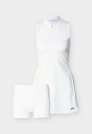 Mouwloze witte sportjurk met rits aan de voorkant en bijpassende witte strakke shorts, beide voorzien van een klein zwart logo nabij de zoom.