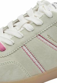 Baskets en daim vert clair avec accents roses, lacets blancs et bandes latérales texturées. Conçues avec une semelle en caoutchouc et des détails cousus.