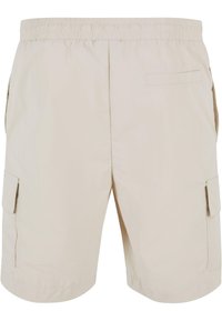 Beige cargo shorts med strikk i livet, sidelommer og en baklomme; lett, glatt stoff og knelangt design.