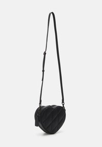 Černá crossbody taška ve tvaru srdce vyrobená z umělé kůže s prošívanou texturou. Má nastavitelné rameno a zipové zavření.
