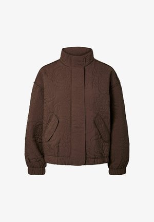 Ruskea tikattu takki, jossa on korkea kaulus. Takissa on kukkakuvioita, kaksi sivutaskua sekä joustavat hihansuut ja helma.