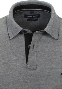 Sort og grå mønstrede polo-shirt med krave, knaplukning og indvendig sort detalje; lavet af strækstof for komfort.