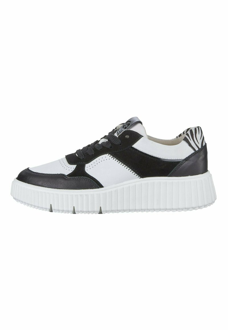 Baskets noir et blanc avec une semelle en caoutchouc texturé, des accents en cuir et en daim, présentant un motif zèbre sur le talon et les lacets.
