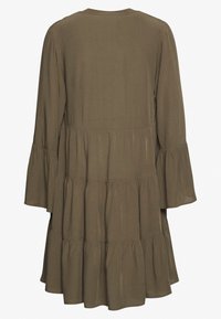 Olivgrön lager-på-lager-klänning gjord av mjuk tyg, med långa klockärmar och rund halsringning, samt en flödande silhuett.