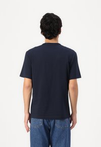 Ναυτικό μπλε βαμβακερό T-shirt με κοντά μανίκια και στρογγυλή λαιμόκοψη, απεικονιζόμενο από πίσω, με λεία υφή και χωρίς ορατά σχέδια.