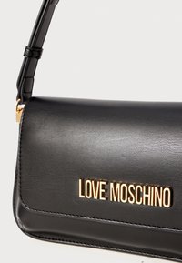 Black leather handbag with a gold "LOVE MOSCHINO" logo, featuring a smooth texture, rectangular shape, and a slim strap.