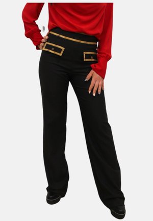 Pantaloni neri con vita alta, bordatura dorata a contrasto su tasche e cintura, e una vestibilità sartoriale. Tessuto liscio con una leggera lucentezza.