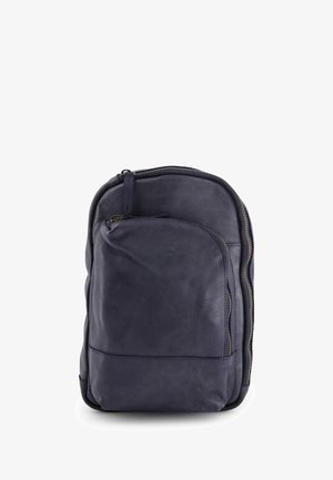 Navy Leder-Rucksack mit gerundeter Form, glatter Oberfläche, vorderer Reißverschlusstasche und kontrastierenden goldfarbenen Reißverschlussbeschlägen.