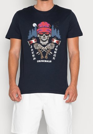 Marineblauw katoenen T-shirt met een kleurrijke schedelafbeelding, gekruiste bijlen en tekst. Korte mouwen en een ronde hals; losse pasvorm.