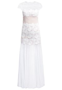 Robe superposée en dentelle blanche et tulle transparent avec manches courtes, motifs floraux, détails à pois et jupe longue fluide.