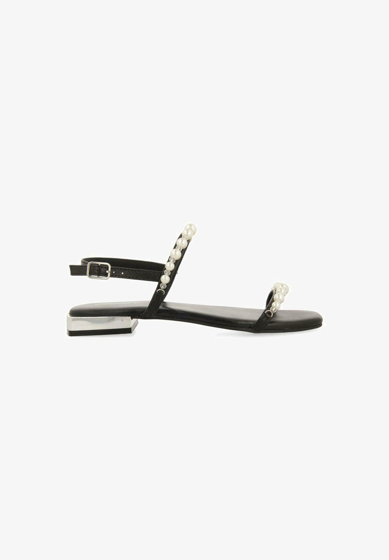 Must have kahe pärliaktsentide ja reguleeritava pandlaga mustad lamedad sandaalid, metallist plokk-kandaga. Vaatamata oma lihtsale disainile on sandaalidel sile ja pehme tekstuur.