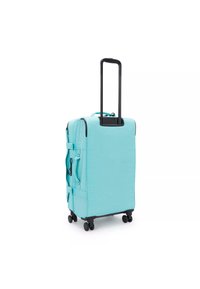 Hard-shell suitcase in light turquoise, with a retractable black handle, four wheels, and side compression straps. Textured surface detail.