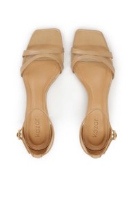 Beige sandaalit, joissa on neliömäinen kärki, sileä nahkamateriaali, litteä pohja ja nilkkaremmi, jossa on metallisolki.