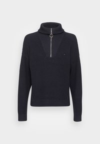 Pull marin à col roulé avec demi-zip, texture côtelée et subtil motif en V sur le devant. Présente un petit logo sur la poitrine.