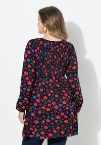 Kwiatowa sukienka na czarnym tle, z kolorowymi kwiatami w odcieniach różu, niebieskiego i zielonego. Długie, bufiaste rękawy oraz marszczony detal z tyłu.