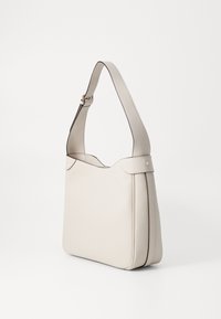 Borsa a tracolla in pelle beige con un design elegante, caratterizzata da una parte superiore curva, una tracolla regolabile e un delicato cucito a contrasto lungo i bordi.