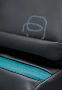 Zwarte stoel met een gladde textuur en een turkooizen accent met een ritssluiting. Bevat een grijs logo in een minimalistisch ontwerp.