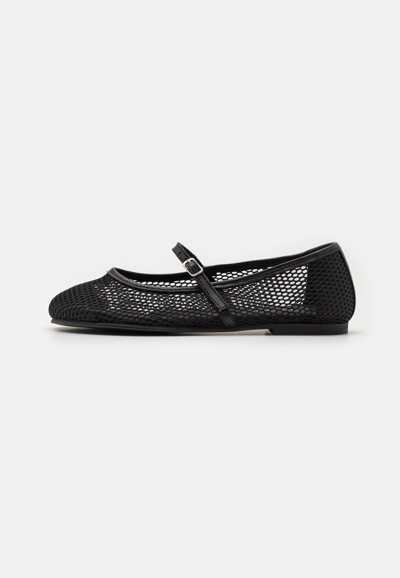 Chaussure plate Mary Jane en mesh noir avec une fine bride et une petite boucle, talon bas et bout arrondi, sur fond blanc uni.