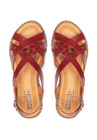 Rode leren sandalen met een kruisbandontwerp, tankleurige binnenzool en gestikte details. Voorzien van een kleine enkelband met een metalen gesp.