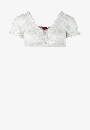 Kobieta ubrana w tradycyjną bawarską sukienkę dirndl z białą bluzką, niebieskim kwiecistym gorsetem, czerwoną kraciastą spódnicą, białymi dzianinowymi pończochami i beżowymi butami.