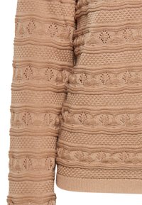 Beige kötött pulóver texturált csíkokkal, geometriai kivágásokkal és emelt mintákkal. Puha anyag ribbelt mandzsettákkal és aljjal.