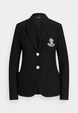 Svart blazer med to sølvknapper, to frontlommer og et brodert logo på brystlommen. Teksturert stoff, tettsittende design.