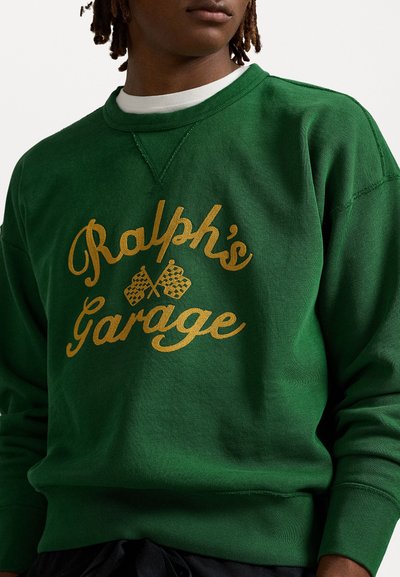 Green sweatshirt featuring gold script reading "Ralph's Garage" with racing checkered flag accents. Textured fabric and crew neckline.