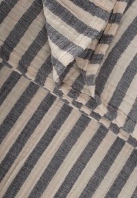 Striped fabric with alternating light beige and dark blue-gray lines, featuring a soft texture and visible stitching along the edges.