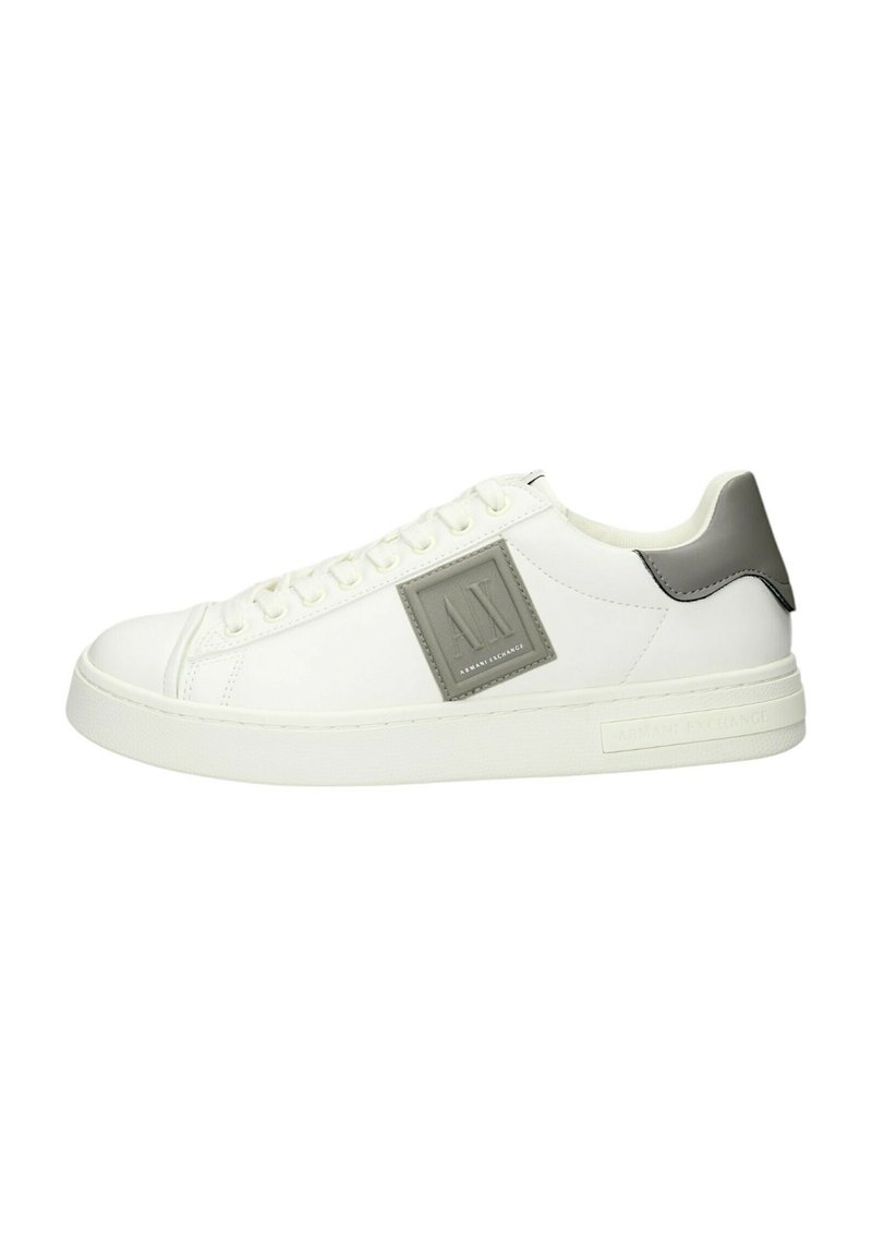 Sneaker bianco con parte superiore in pelle liscia, accentuazione grigia sul tallone e fascetta con logo testurizzato sul lato. Punta rotonda e suola in gomma piatta.