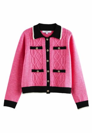 Różowy sweter w warkocze z czarno-białym wykończeniem kołnierza oraz czarną prążkowaną naszywką z złotym teksturowanym guzikiem.