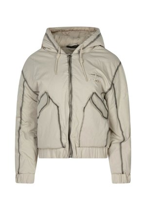 Veste matelassée beige au design court, fermeture éclair, capuche, et détails contrastants noirs le long des coutures et des poches.