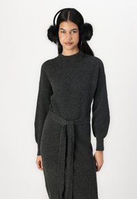 Kolgrå stickad klänning med hög hals, långa puffärmar och ett matchande bälte av samma tyg, med ribbat mönster genom hela klänningen.