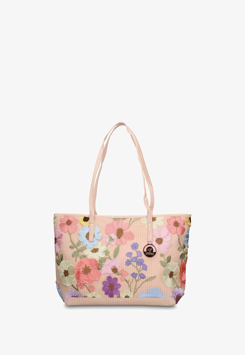Sac cabas rose avec des fleurs multicolores brodées, deux poignées en tissu, et une étiquette de marque ronde en métal à l'avant.