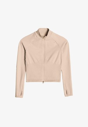 Veste beige zippée avec manches longues, texture côtelée et design court. Présente des manches raglan et des fentes sur les poignets.