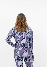 Langarmshirt im lila und hellblauen Tarnmuster, aus einem glatten, dehnbaren Stoff mit einer lockeren Passform.