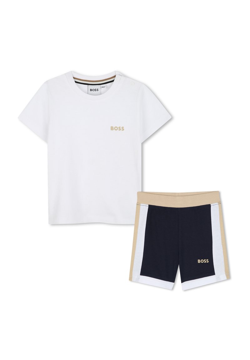 Hvit kortermet T-skjorte med gull "BOSS"-logo; sammen med marineblå, beige shorts med hvite side-striper og elastisk midjebånd.