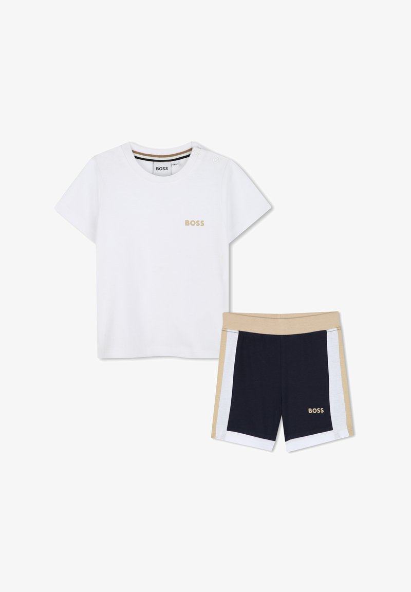 Balta trumpomis rankovėmis T-shirt su auksiniu "BOSS" logotipu; derinama su tamsiai mėlynomis, smėlio spalvos šortais su baltais šoniniais juostelėmis ir elastiniu juosmeniu.