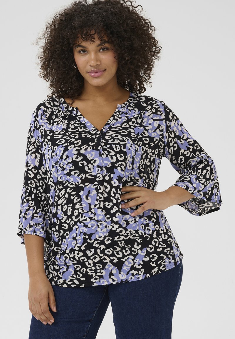 Blomstret blouse i sort med lilla og creme leopardmønstre, med V-hals og trekvart ærmer med klokkeform. Blødt, tekstureret stof.