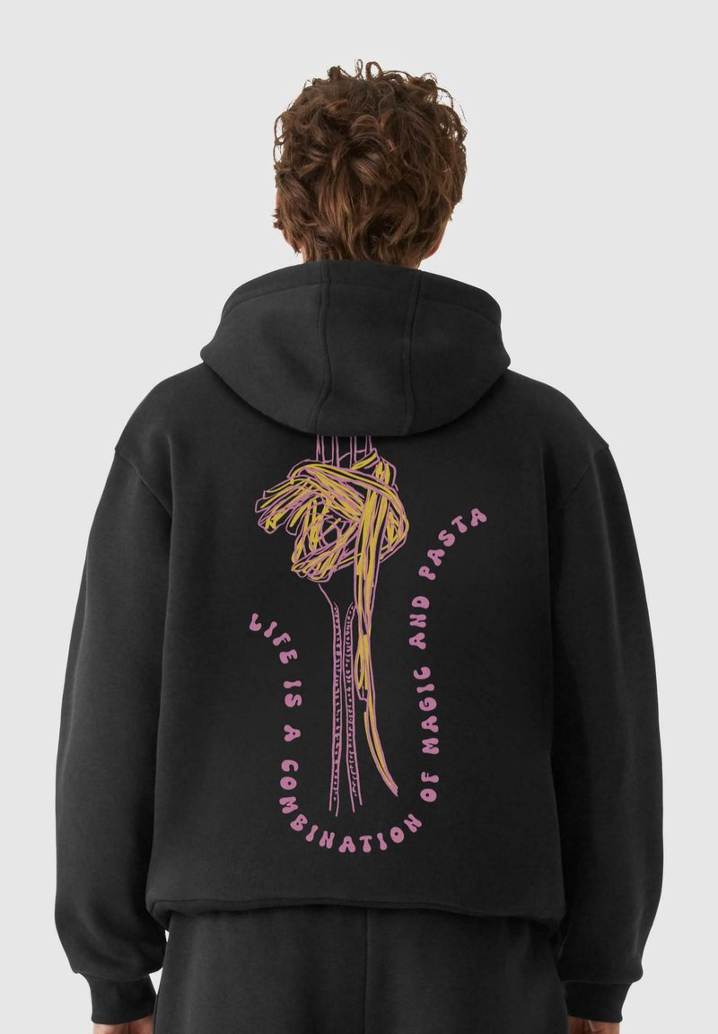 Felpa nera oversize con un design di forchetta e pasta gialla, e testo rosa che recita "La vita è una combinazione di magia e pasta" sul retro.