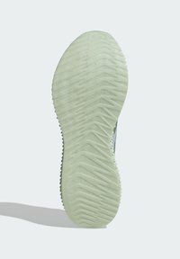 Zool van een sneaker met een gestructureerd, lichtgroen oppervlak, met duidelijke zigzagpatronen voor grip en tractie.